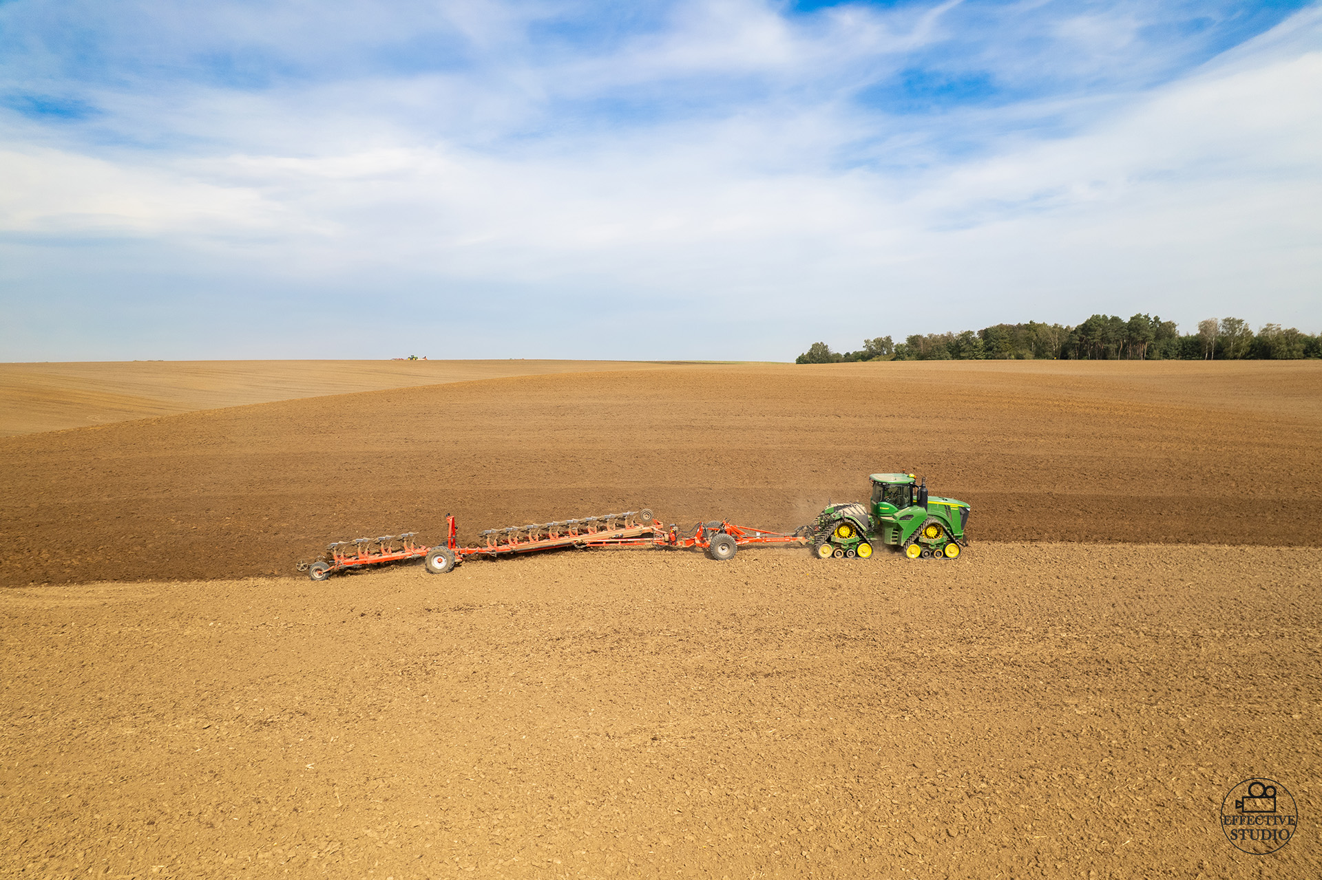 Ciągnik John Deere podczas orki pola – usługi dronem